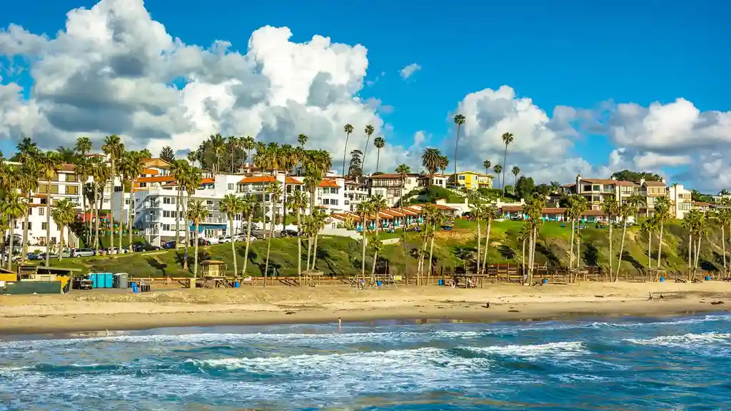 Close up on a plate of mashed potatoes, topped with baked pork chops with cream of mushroom soup, and a side of green beans.
